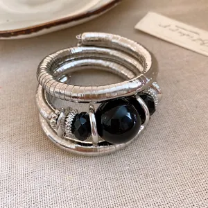 Close-up of vintage multi-layer wrap bracelet with black acrylic beads and silver coils