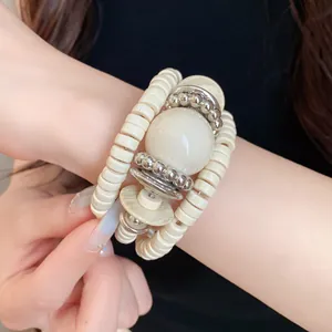 Close-up detail of a vintage multi-layer wrap bracelet with cream acrylic beads and silver
