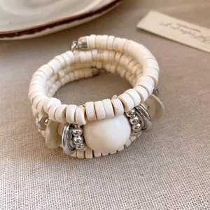 Detail view of retro multi-layer wrap bracelet with cream acrylic beads and silver accents.