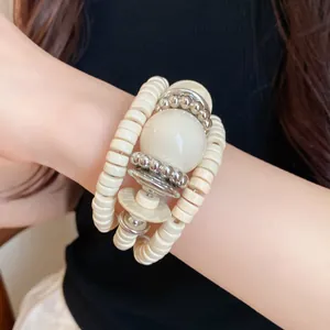 Detail view of a retro multi-layered wrap bracelet with cream acrylic and silver beads