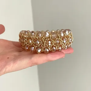 Primer plano de una pulsera vintage de cuentas de cristal champán con detalles en cadena dorada.