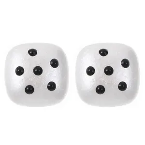Detailed macro view of white pearlescent square earrings with black polka dot design accents