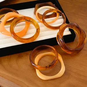 Bracelets minimalistes en résine aux formes géométriques irrégulières et circulaires couleur ambre.
