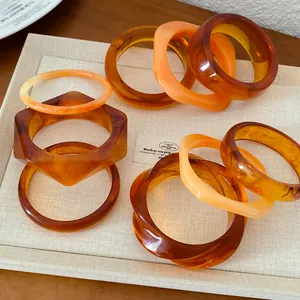 Gros plan sur des bracelets en résine géométriques irréguliers aux tons ambre