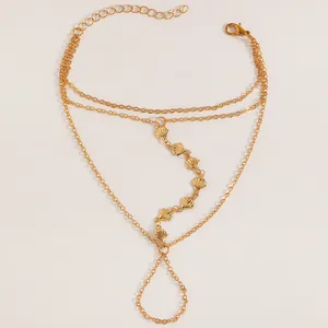 Vue détaillée d'un bracelet de main doré à deux rangs avec breloques en forme de coquillage