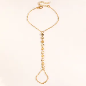 Vue détaillée d'un bracelet bague doré avec des breloques en forme de cœur texturé