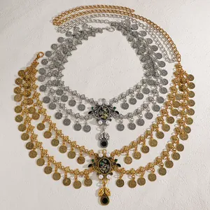 Detailed macro view of vintage ethnic gold and silver coin waist chains with pearl pendants.