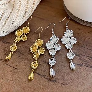 Dettaglio orecchini a fiore con nappa e pendenti a goccia in finitura oro e argento