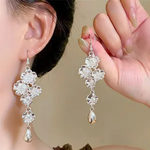 Dettaglio di orecchini a nappa floreale color argento con pendenti a goccia retro