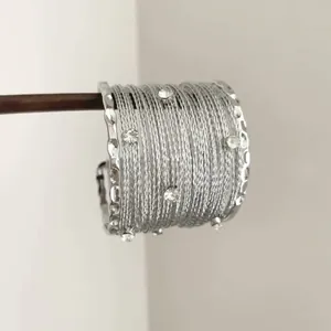 Gros plan d'un bracelet manchette argenté multi-rangs orné de cristaux brillants