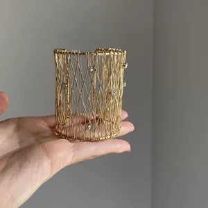 Détail d'un bracelet manchette en fil d'or tissé avec cristaux incrustés