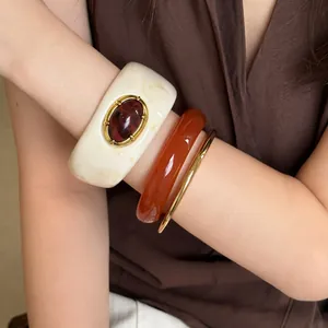 Primer plano de un conjunto de pulseras de acrílico vintage en ámbar y oro