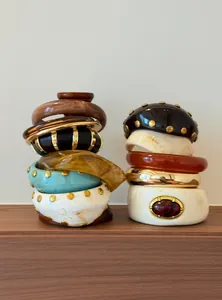 Primer plano de brazaletes vintage de resina acrílica con tachuelas doradas y mármol
