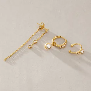 Detailset aus drei goldenen Edelstahl-Ohrringen mit funkelnden Zirkonia und Quasten.
