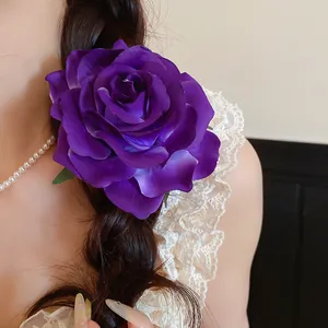 Detailansicht einer realistischen, großen lila Rosen-Haarspange in einem dunklen Zopf.