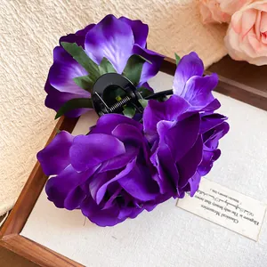 Detailansicht einer violetten künstlichen Rosenspange auf hölzernem Tablett