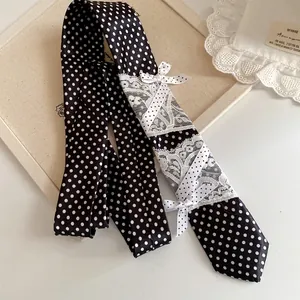 Gedetailleerde weergave van de zwart-witte polkadot stropdas met kant en strikjes
