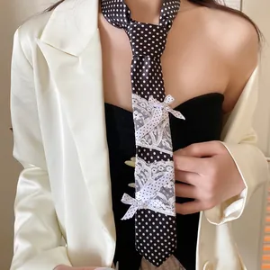 Detailweergave van een zwarte gestipte stropdas ketting met kant en witte strikken.