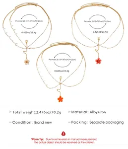 Macro view of gold body chains with flower charms and measurement details displayed.