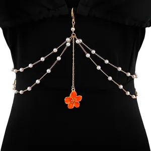 Elegant multilayer gold body chain with white pearls and orange flower charm detail.