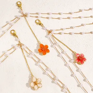 Detail shot of multilayer body chains with colorful flower pendants and pearls