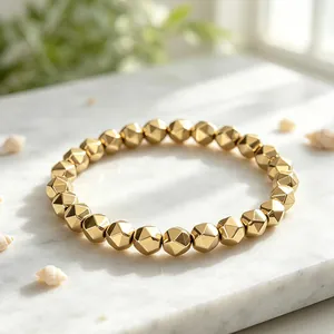 Detailed macro view of faceted gold pyrite beaded bracelet displayed on elegant marble stone