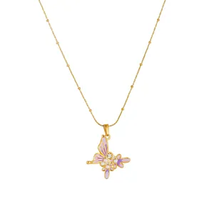 Détail du collier en acier doré avec pendentif papillon violet et perles délicates
