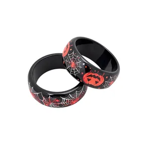 Coppia di braccialetti di Halloween in resina con ragnatele e zucche su fondo nero