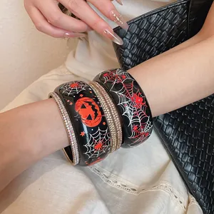 Dettaglio di braccialetti di Halloween in resina con ragnatela e motivi di zucca