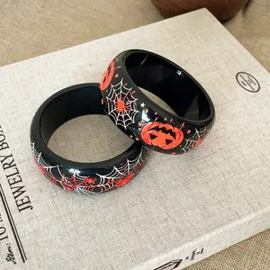 Dettaglio di braccialetti di Halloween in resina nera con ragnatele e zucche stampate
