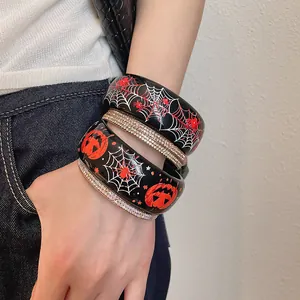 Primo piano di bracciali di Halloween in resina con ragnatele, zucche e dettagli in strass.