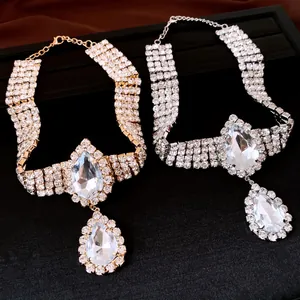 Close-up of gold and silver necklaces featuring large rhinestone water drop pendants