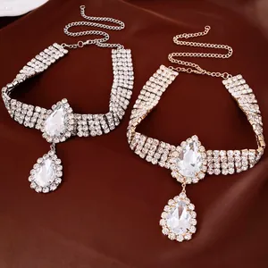 Close-up of sparkling teardrop pendant necklaces in gold and silver finishes