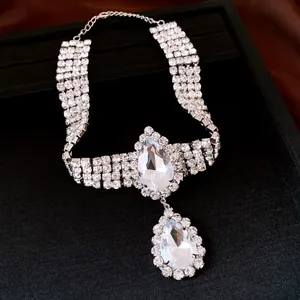Close-up of sparkling teardrop crystal pendant on multi-row rhinestone necklace