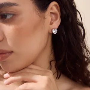 Detailed view of a heart-shaped zircon stud earring worn on a female model's ear