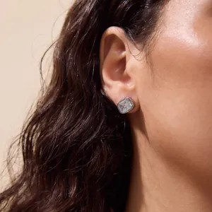 Close-up detail of a square bezel-set zirconia stud earring worn on a female ear lobe