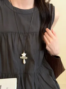 Detail view of retro ethnic style long necklace with star and waterdrop stone pendants.
