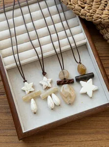 Detailed view of retro ethnic necklaces with star and droplet charms on jewelry tray