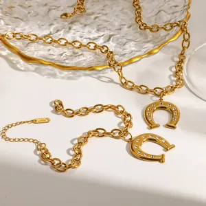 Close-up detail of 18k gold plated stainless steel horseshoe pendant jewelry set