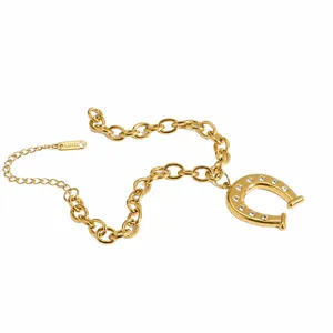 Detailed shot of a gold-plated stainless steel horseshoe pendant on a thick link chain.