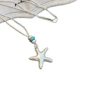 Collier pendentif étoile de mer argent brossé minimaliste avec perle turquoise pour femme.
