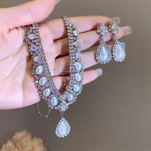 Vista macro dettagliata della collana di strass argentati con orecchini di perle a goccia