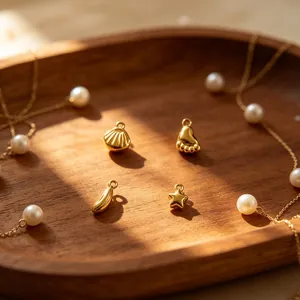 Nahaufnahme goldener Edelstahl-Anhänger mit Muschel-, Stern- und Fußform