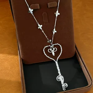Vista detallada del collar con colgante de llave de corazón con perla y flores elegantes
