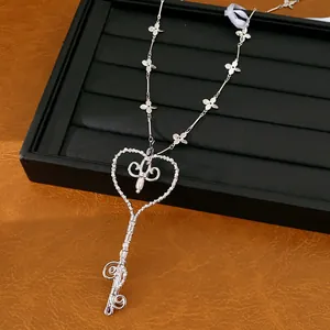 Elegante collar con colgante de llave de corazón, detalles florales y toques de perlas.
