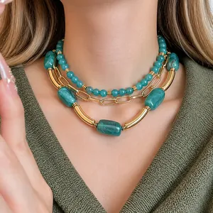 Elegante collana a più strati di perle acriliche con accenti dorati indossata da una modella