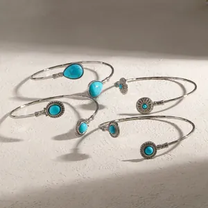 Détails de joncs vintage en argent ornés de pierres turquoise sur un support texturé