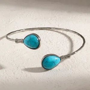 Vue détaillée d'un bracelet vintage argenté avec des pierres turquoise en goutte.