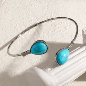 Vue détaillée d'un bracelet jonc vintage martelé orné de deux gouttes turquoises.