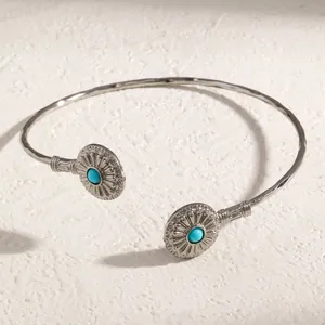 Vue détaillée d'un bracelet jonc ethnique avec incrustations de turquoise sur fond texturé